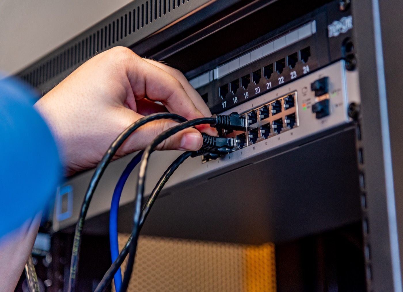 Hands connecting network equipment during Digital Wave field work