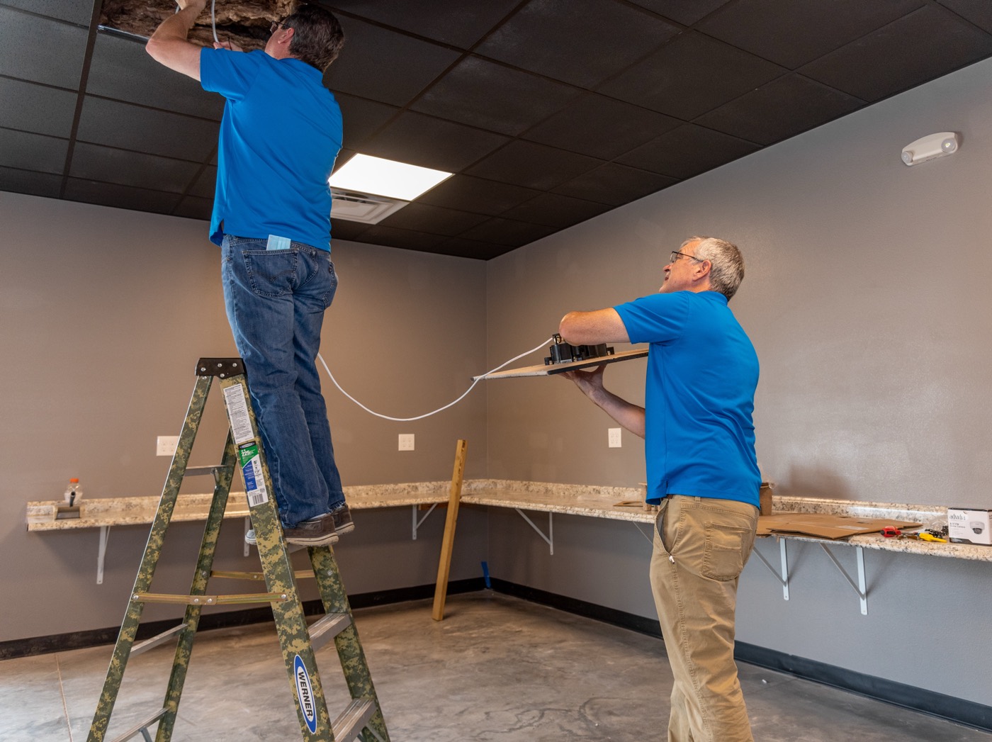 A Digital Wave technician installing connectivity above a ceiling
